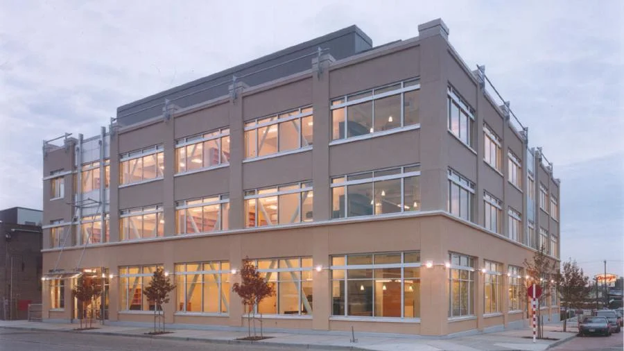 Modern office building at 960 Republican Street in Seattle with expansive glass windows illuminated at twilight