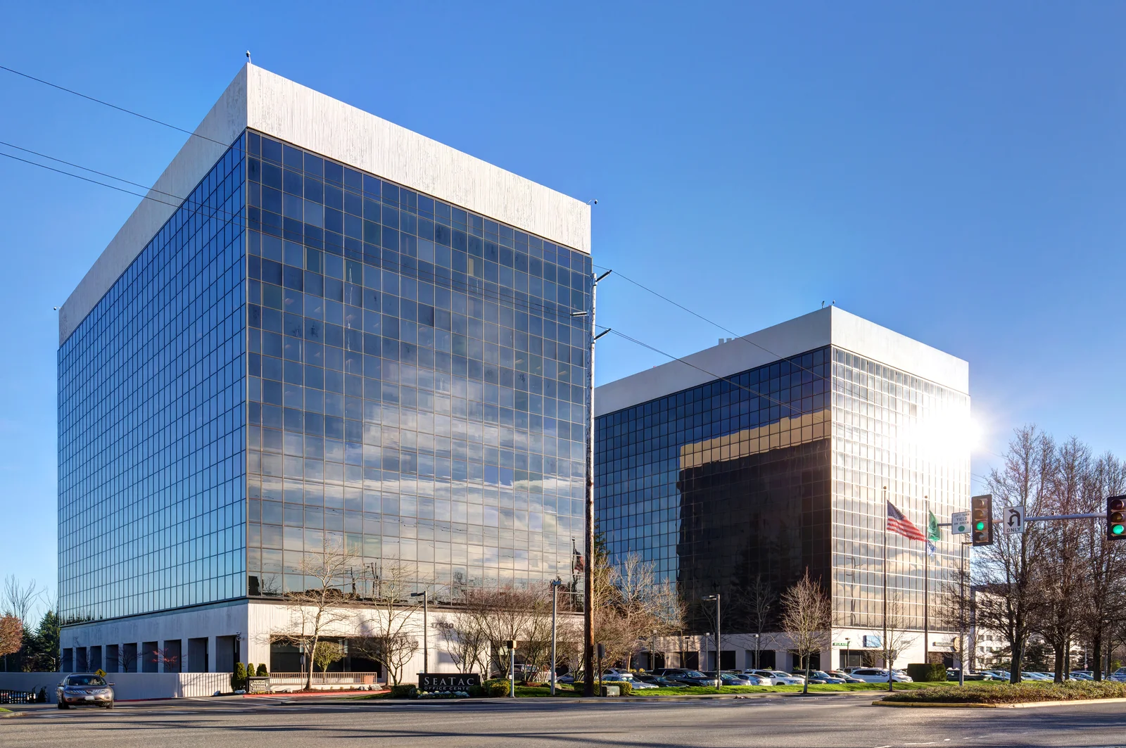 International Place dual-tower office campus at 18000 Pacific Highway South in SeaTac featuring blue-tinted glass facades and street-level plaza