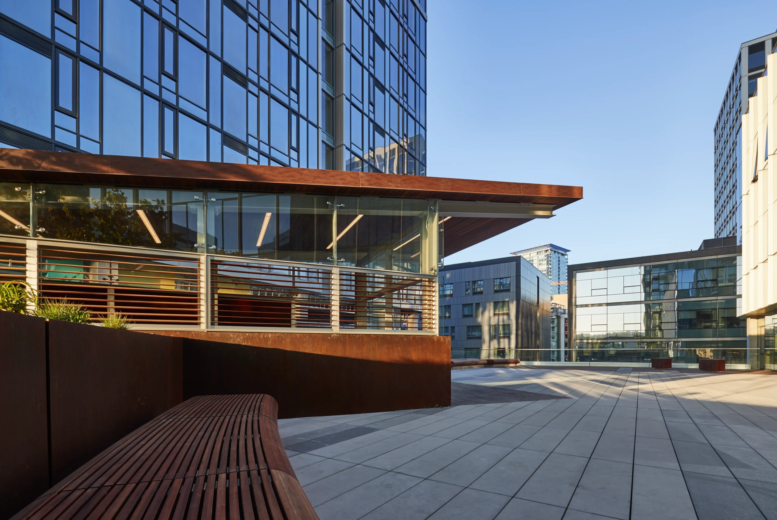 Amenity deck of Tilt49 at 1812 Boren Avenue in Seattle featuring built-in bench seating and planter boxes with blue glass tower above