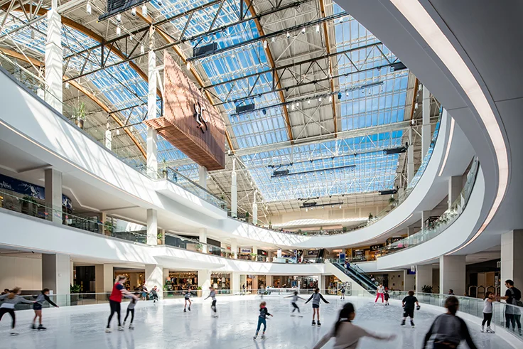 Lloyd Center interior in Portland Oregon with ice skating rink, curved white balconies, and glass skylight ceiling