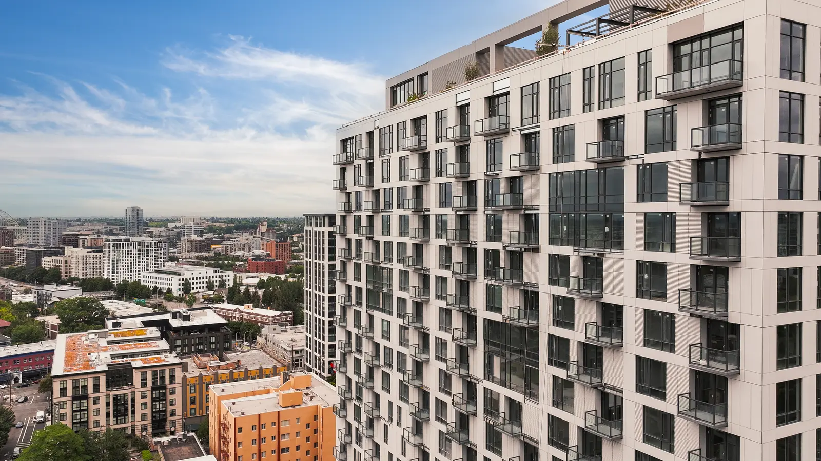Aerial photo of Byline apartments at 1640 SW Yamhill Street in Portland featuring modern rooftop amenity deck and views of city skyline.